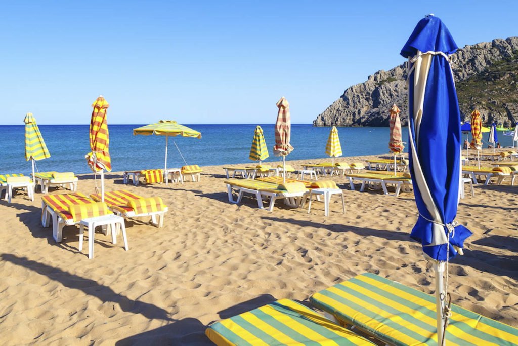 Tsambika empty sunbeds along sandy beach