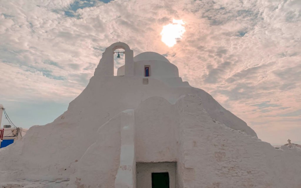 Sun shining behind Mykonos church